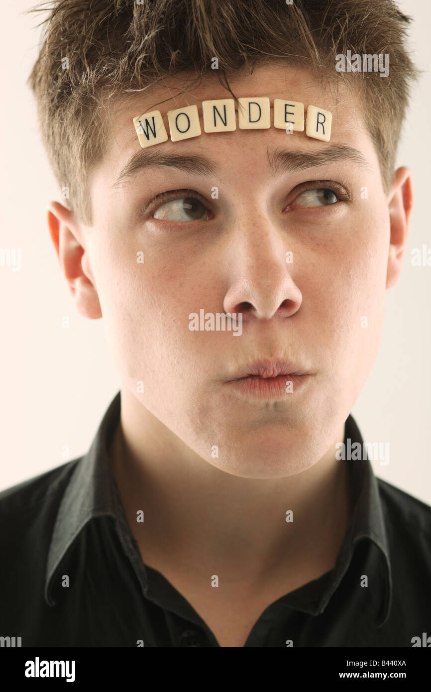 Uomo con la parola 'wonder' scritto con lettera piastrelle sulla sua testa Foto Stock