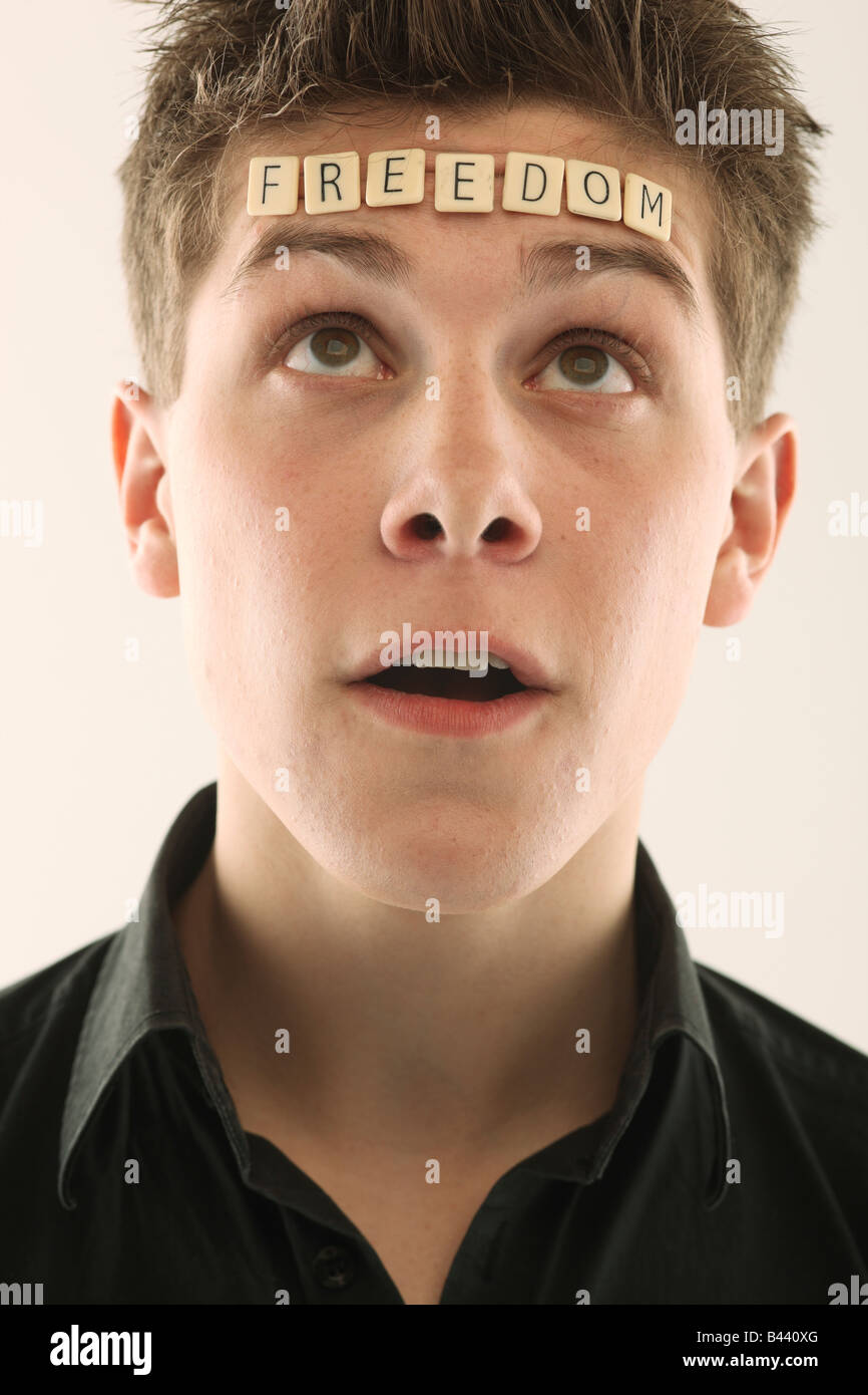 Uomo con la parola "libertà" scritto con lettera piastrelle sulla sua testa Foto Stock