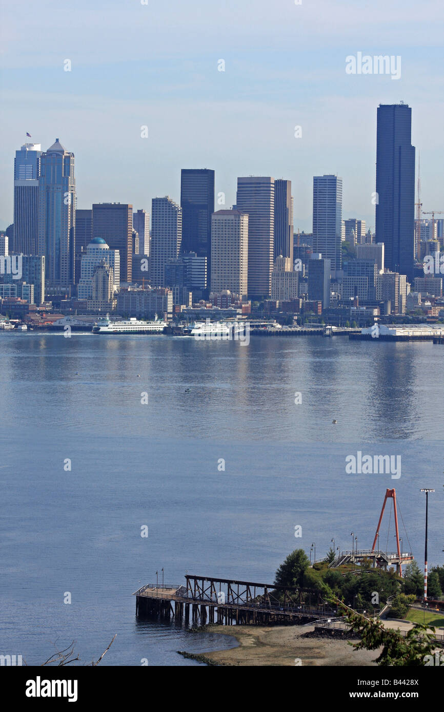 Un dock solitario in primo piano del centro cittadino di Seattle skyline, con riflessioni di grattacieli in acque di Elliot Bay. Foto Stock