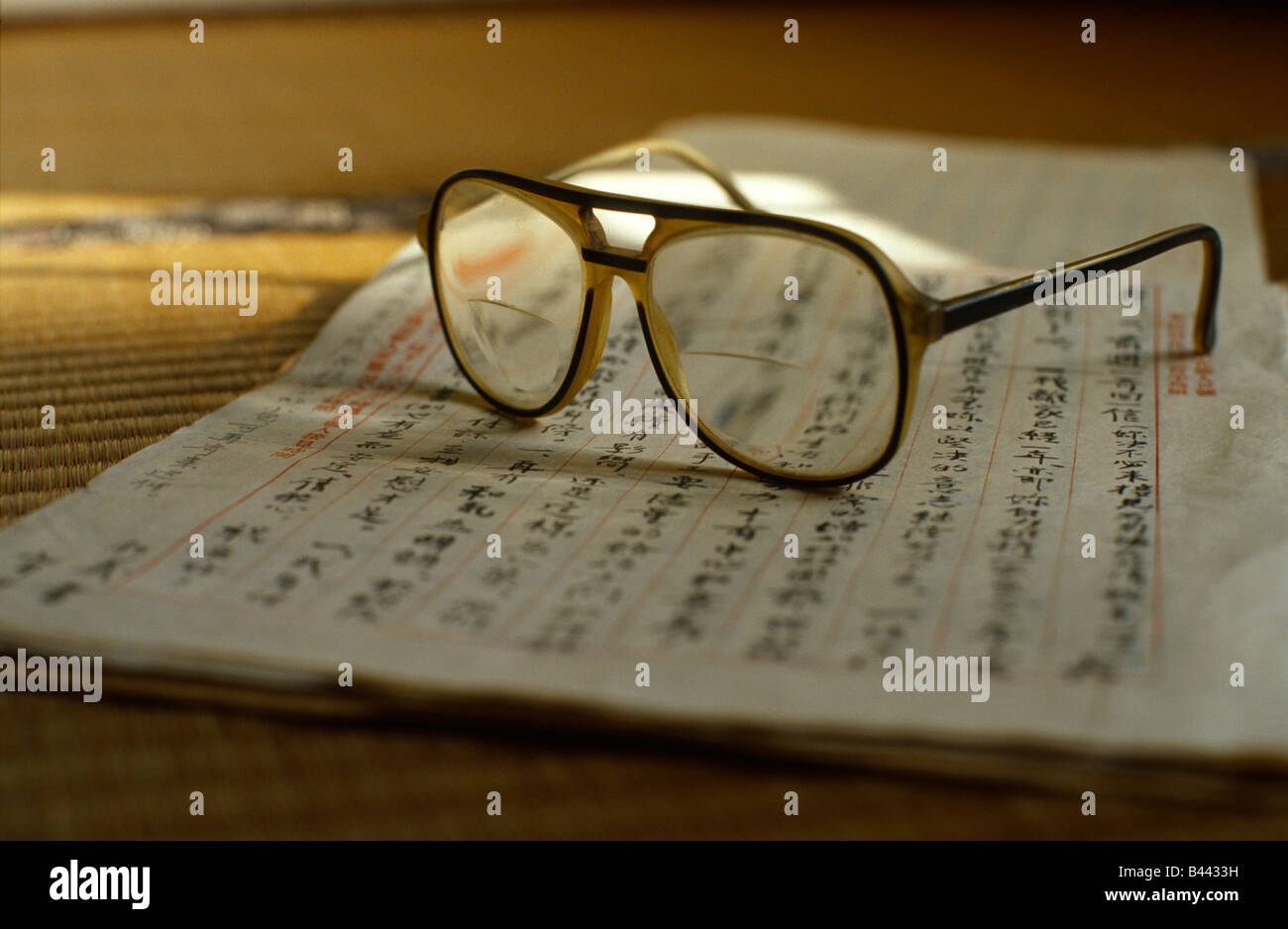 Vecchi occhiali sulla parte superiore di una vecchia lettera scritta in Cinese. Foto Stock