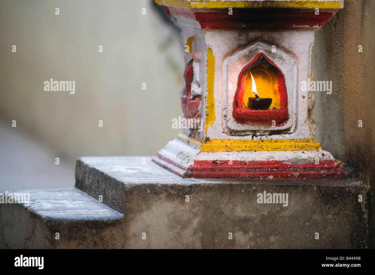 Santuario indiano con una lampada ad olio fiamma al di fuori di una zona rurale villaggio indiano house. Andhra Pradesh, India Foto Stock Santuario indiano con una lampada ad olio fiamma al di fuori di una zona rurale villaggio indiano house. Andhra Pradesh, India Foto Stock