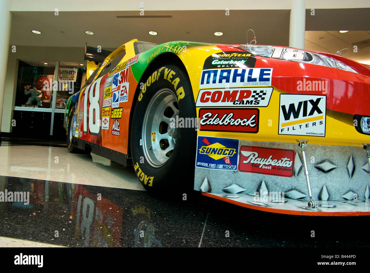 Kyle Busch il numero 18 Toyota Camry NASCAR Race Car con sponsor le decalcomanie su display a Joe Gibbs Racing showroom Foto Stock