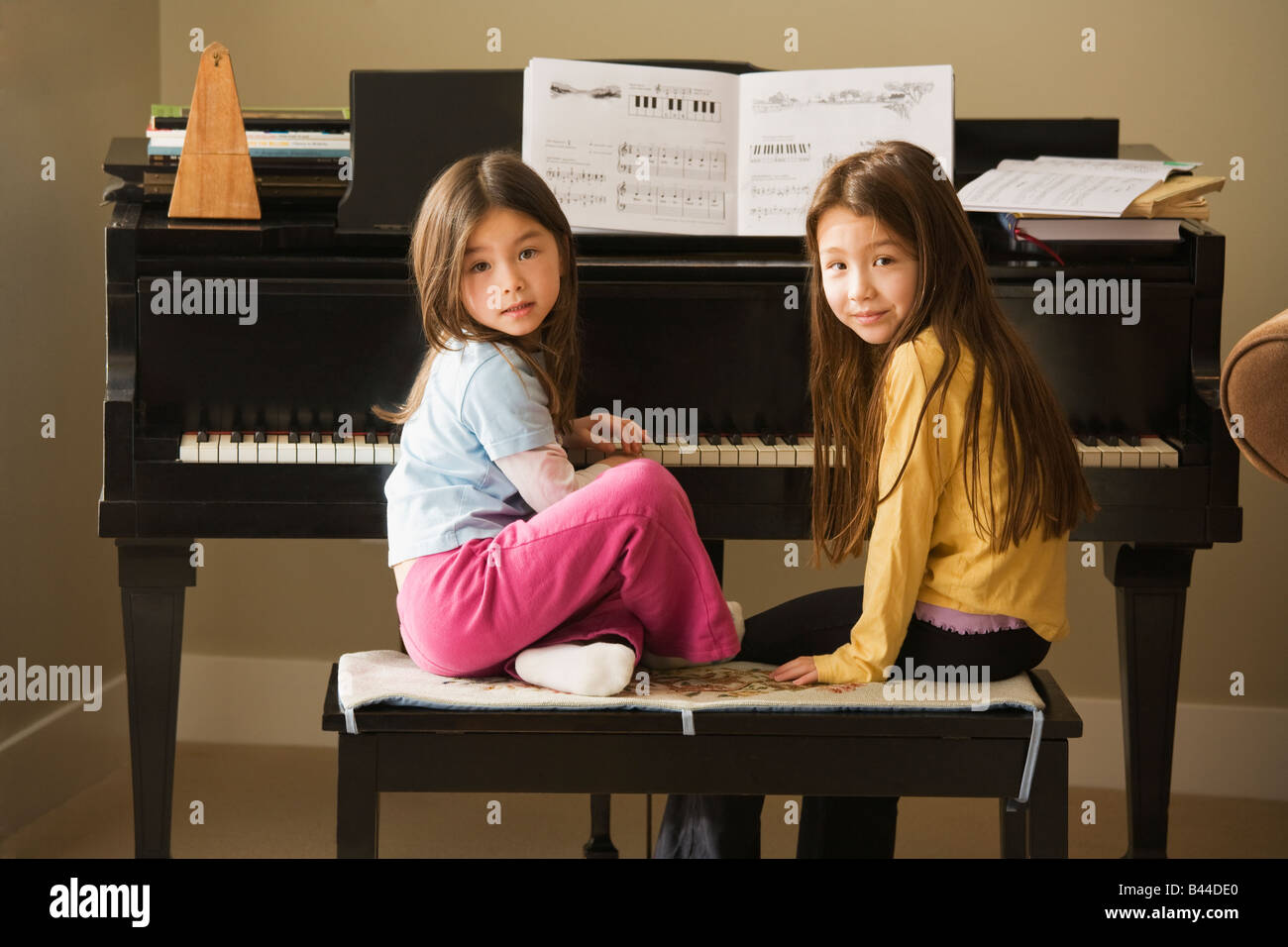 Sorelle asiatiche seduti al pianoforte Foto Stock