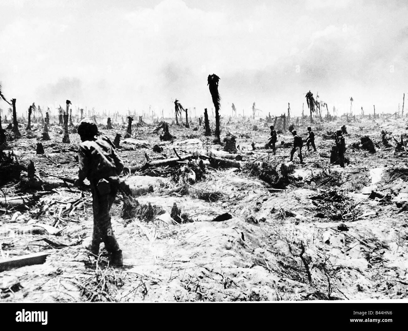 Marines americani anticipo su Barry Island nelle Isole Marshall in scia di fuga le truppe giapponesi gli alberi o sono state sradicate o deleafed dal bombardamento prima l'invasione americana WW2 1944 Foto Stock