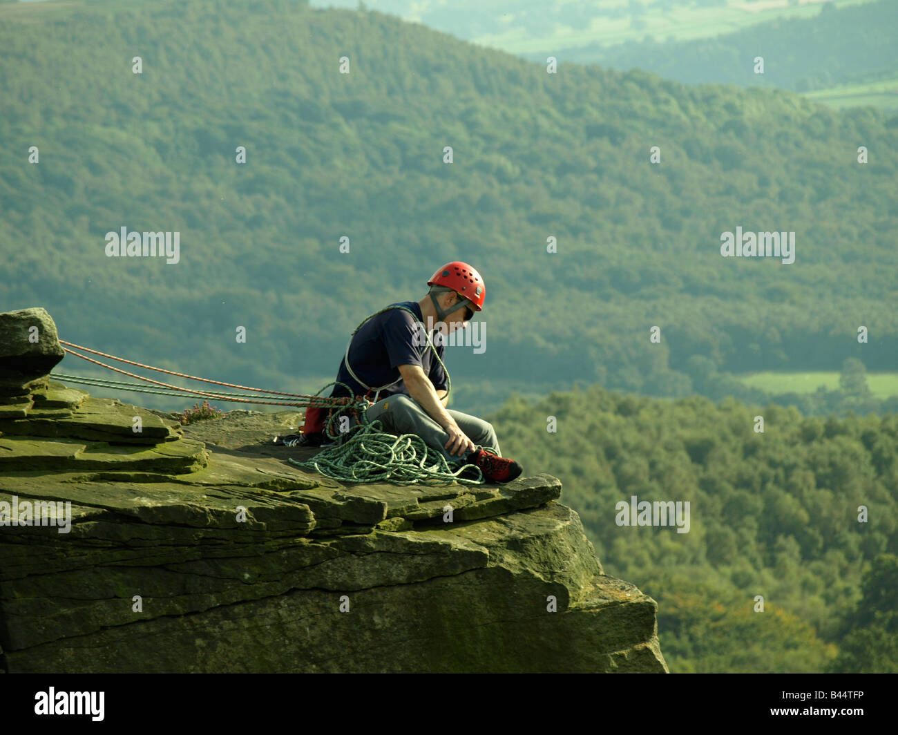L'uomo belaying in cima a una roccia salire Foto Stock