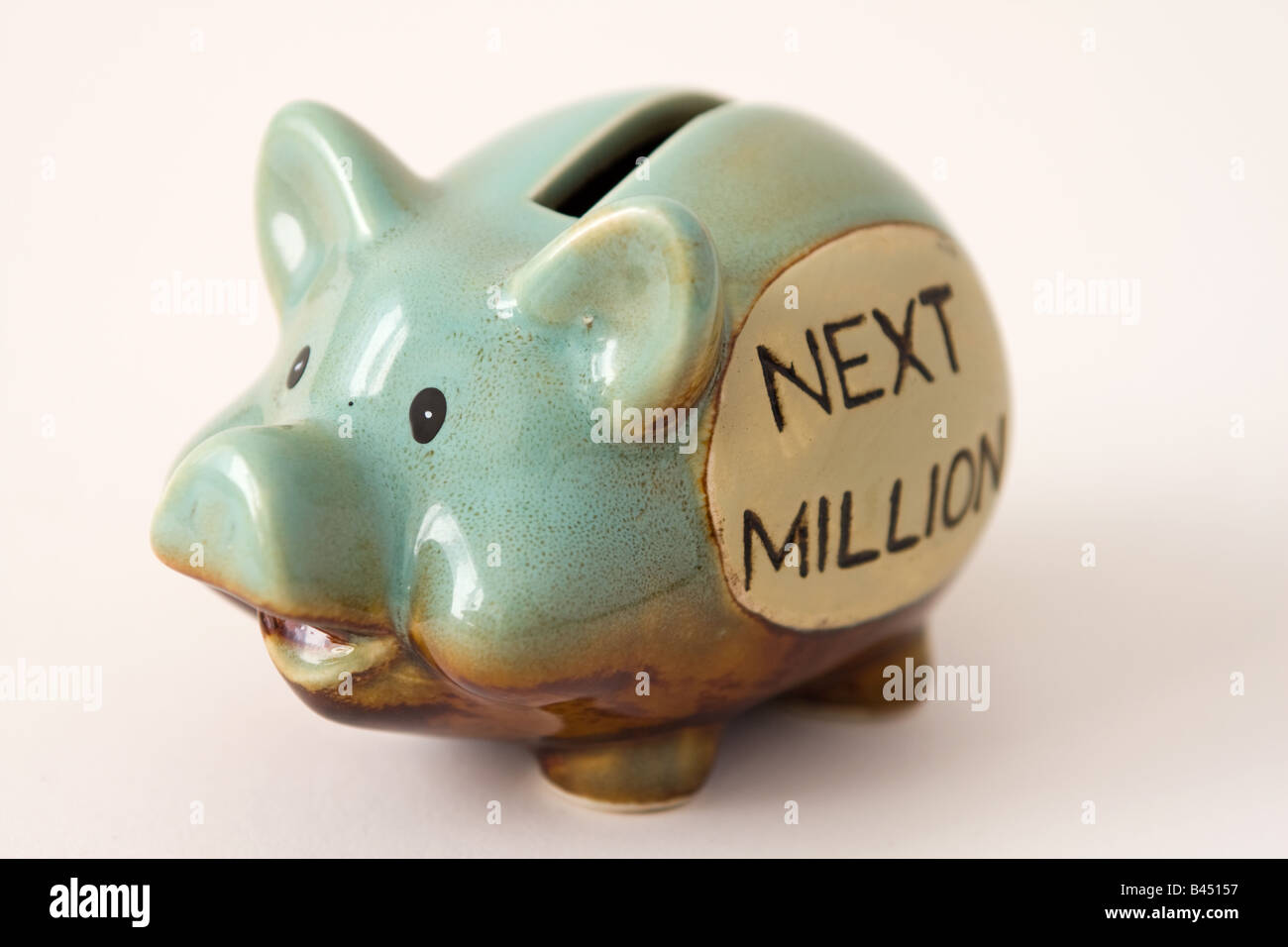 Studio fotografico di stile di una piccola piggy-banca casella di denaro con le parole 'avanti milioni di' sul lato. Foto Stock