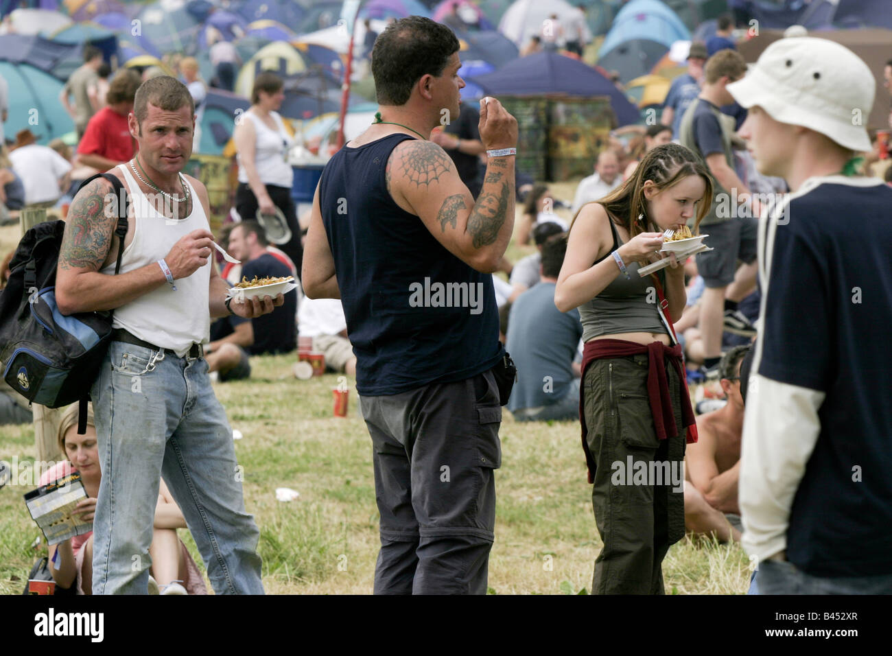 Mangiare tagliatelle. Una vasta gamma di alimenti è disponibile presso oltre 100 bancarelle. Glastonbury Festival Musicale 2003 tenutasi nel Somerset, Regno Unito Foto Stock