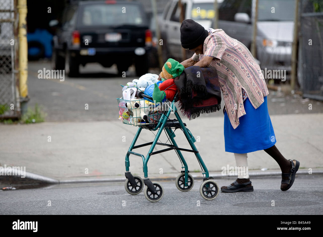 Il sambuco donna con la mascotte di peluche nel carrello walker Queens NY USA Foto Stock