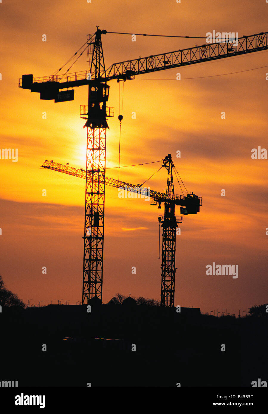 Silhouette di sito in costruzione di gru contro il tramonto Foto Stock