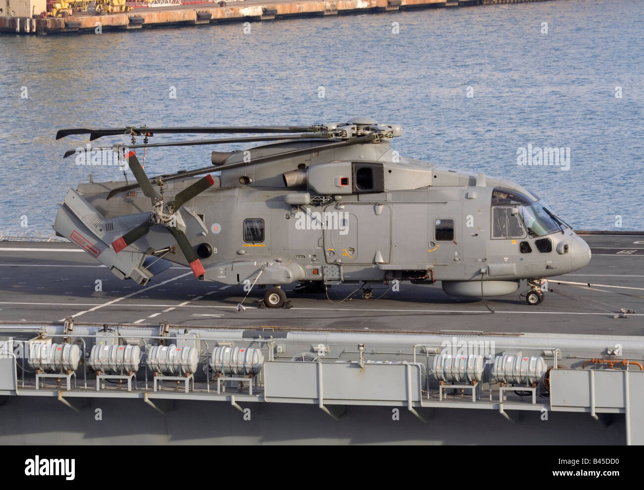 Elicottero militare Royal Navy Merlin con coda e rotore ripiegati sul ponte di HMS Illustrious Foto Stock