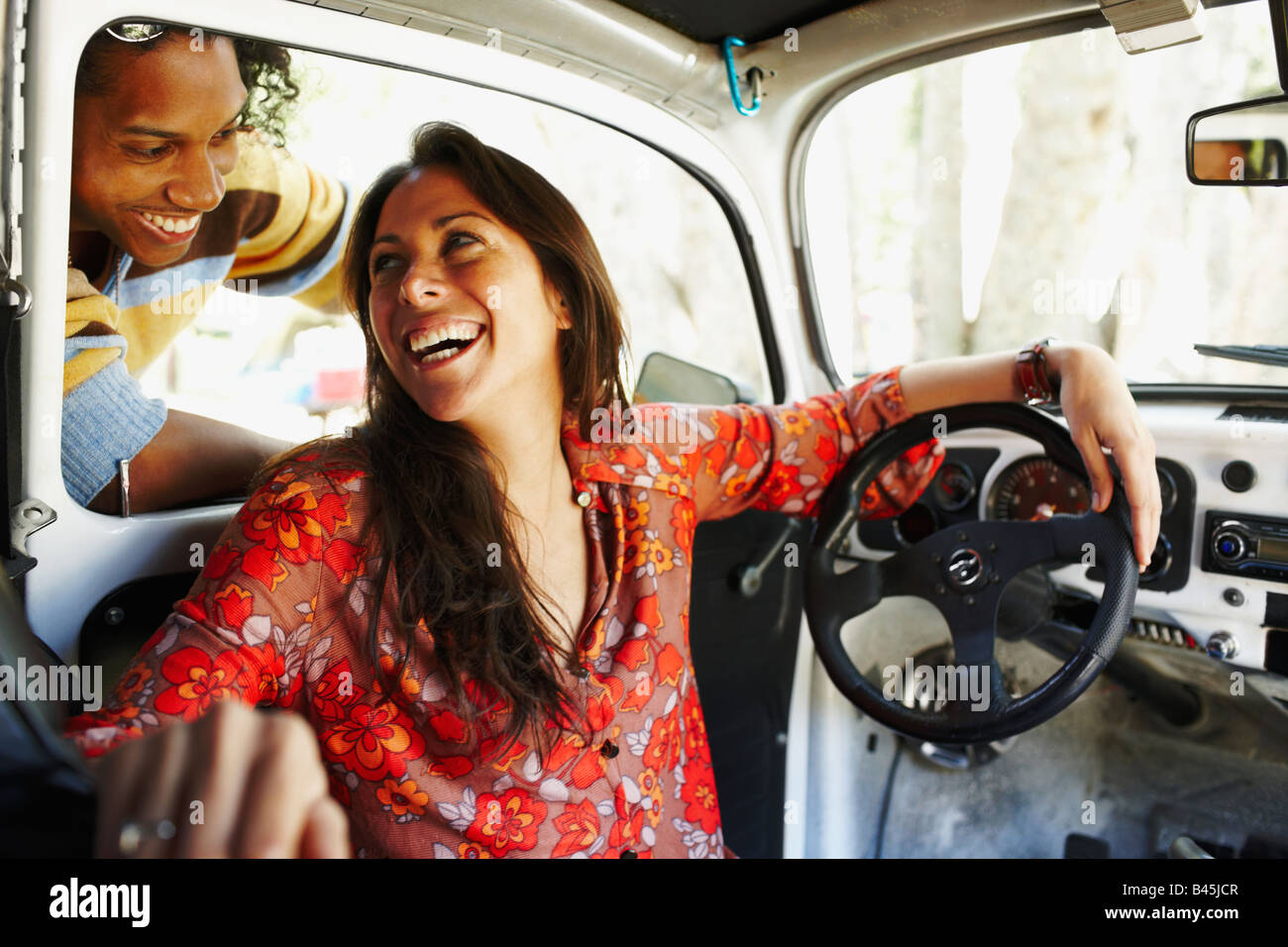 Ispanico donna seduta all'interno dell'auto ridere per amico Foto stock -  Alamy