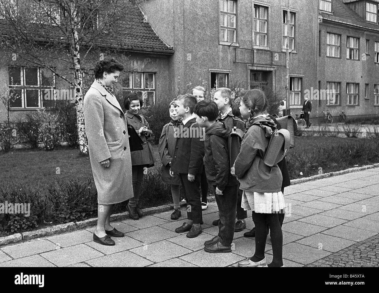 Istruzione, scuola, insegnante e alunni di fronte alla scuola di grammatica 3rd, Berlino Köpenick, 1965, Foto Stock