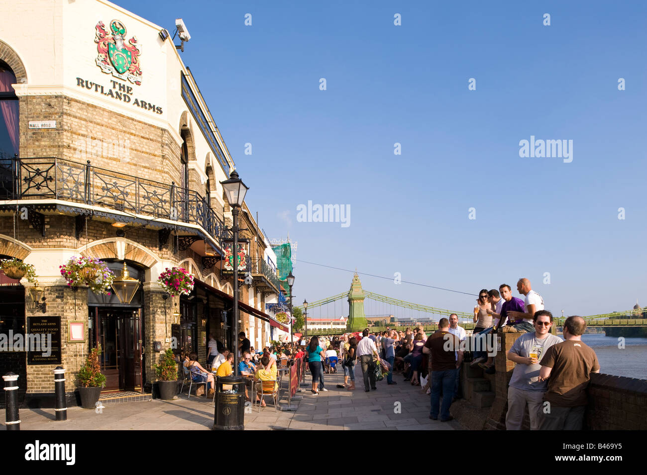 Persone godetevi un drink nel caldo pomeriggio estivo in pub dal Tamigi Hammersmith W6 London Regno Unito Foto Stock