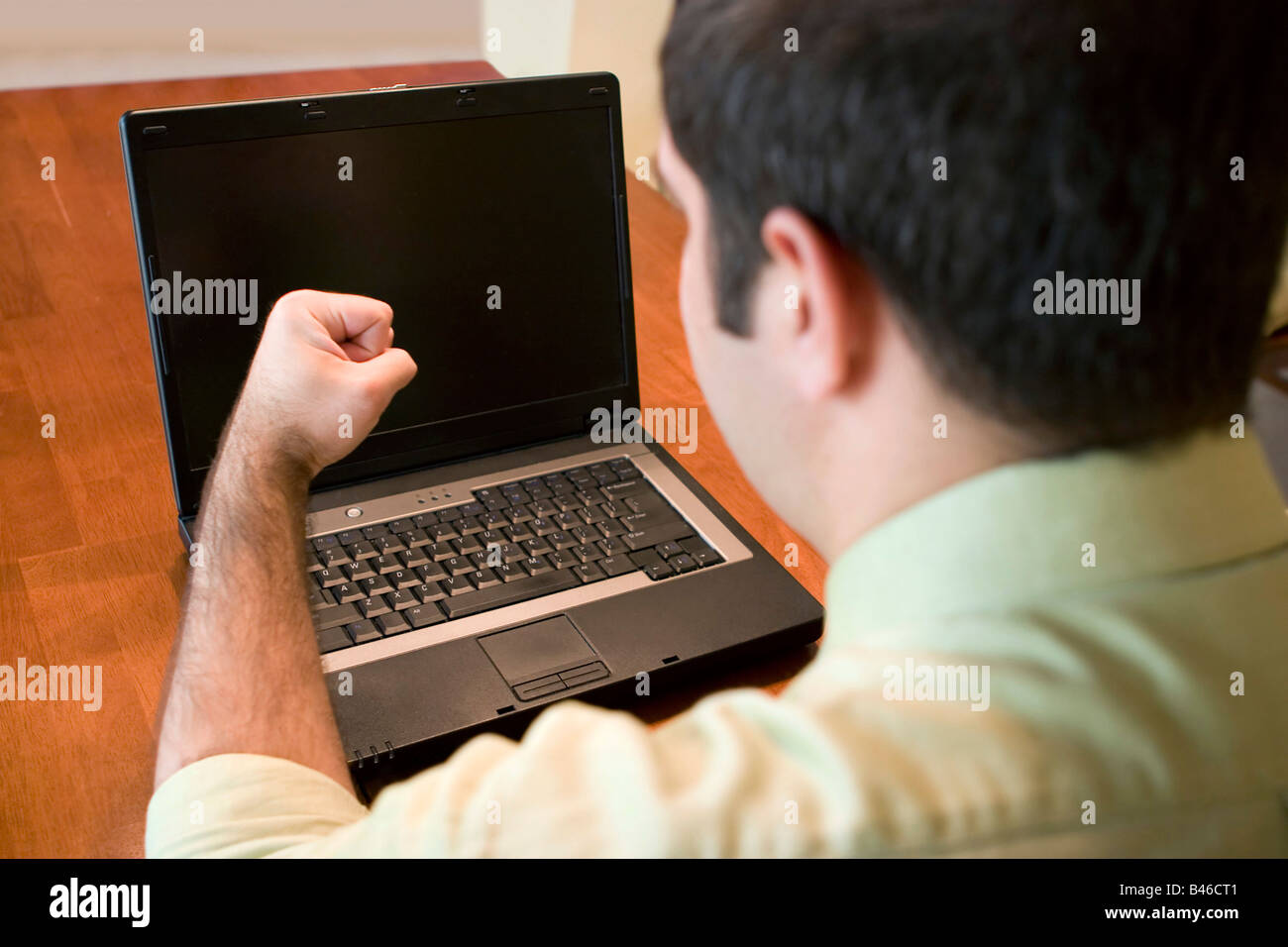 Un giovane uomo di affari ottenere frustrati con il suo computer portatile Foto Stock