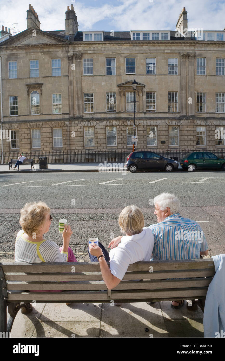 Le persone aventi un tè picnic sulla panchina in street Bath Regno Unito Foto Stock