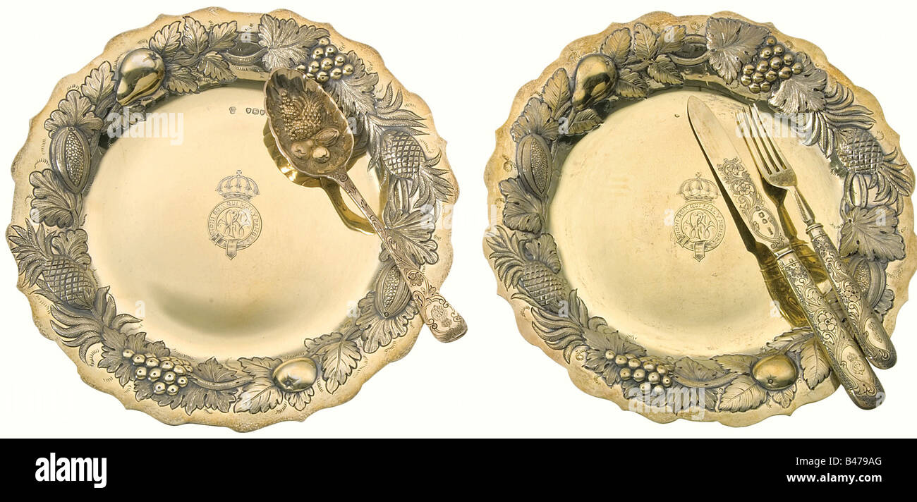 Granduca Friedrich Wilhelm von Mecklenburg-Strelitz (1860 - 1904) - due piatti vermeil e posate dal suo personale tavolo d'argento, Charles Stuart Harris, Londra 1895 - 96. Argento dorato. I bordi dei piatti e le ciotole dei cucchiai sono decorati con un bagno privato con frutta cesellata in rilievo. Le impostazioni del tavolo sono incise con fine decorazione floreale. Il cifrario 'FW' nel nastro Dell'Ordine del Garter sotto la corona di un Granduca è inciso sul centro delle piastre e sulle impugnature dei coltelli, delle forcelle e dei cucchiai. Ogni pezzo sopporta , Foto Stock