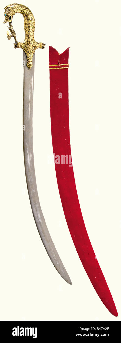 Una tulwar dorato, India, circa 1900 curvata, a bordo singolo, lama di acciaio annacquato con marchi smith stampigliati sul lato opposto. La superficie del hilt di ferro è interamente coperta con decorazione floreale oro-intarsiato e ha un pommel testa mostro. I quillons hanno teste del leone finals. Il fiocco a cavallotto è sagomato come un lepre. Gli occhi sono rispettivamente turchese e rosolia (alcuni mancanti). Scabbard di legno rivestito di feltro. Lunghezza 93 cm. Storico, storico, 1900s, 20th secolo, 19th secolo, spinta, spinte, armi a mano, armi a mano, arma a corpo, mischia Wia, Foto Stock