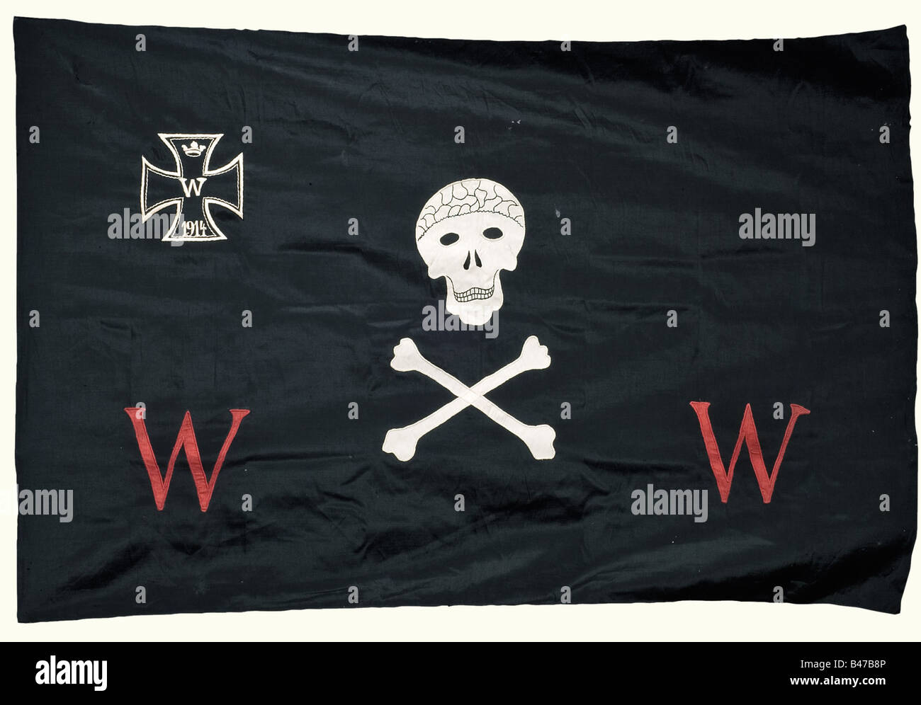 Weimar Republic, Der Wehrwolf (Associazione tedesca degli uomini), un banner, un chiodo di bandiera, e un libro di un membro Banner, presumibilmente per un gruppo locale. Panno nero e doppio in lana, con teschio applicato e ossa incrociate, Croce di ferro 1914 e due cifanti rossi "W" (Wehrwolf). Dimensioni del tessuto 124 x 184 cm. Lieve danno alla falena. Un chiodo a bandiera in lamiera di ottone stampata, 100 x 35 mm con l'emblema Wehrwolf e due rune wolfangel. C'è anche un libro per il Großgörschen Subdistretto/regione di Merseburg, Kötschau Gruppo locale, iniziato nel 1924 con un pin di appartenenza smaltato (danneggiato). , Foto Stock