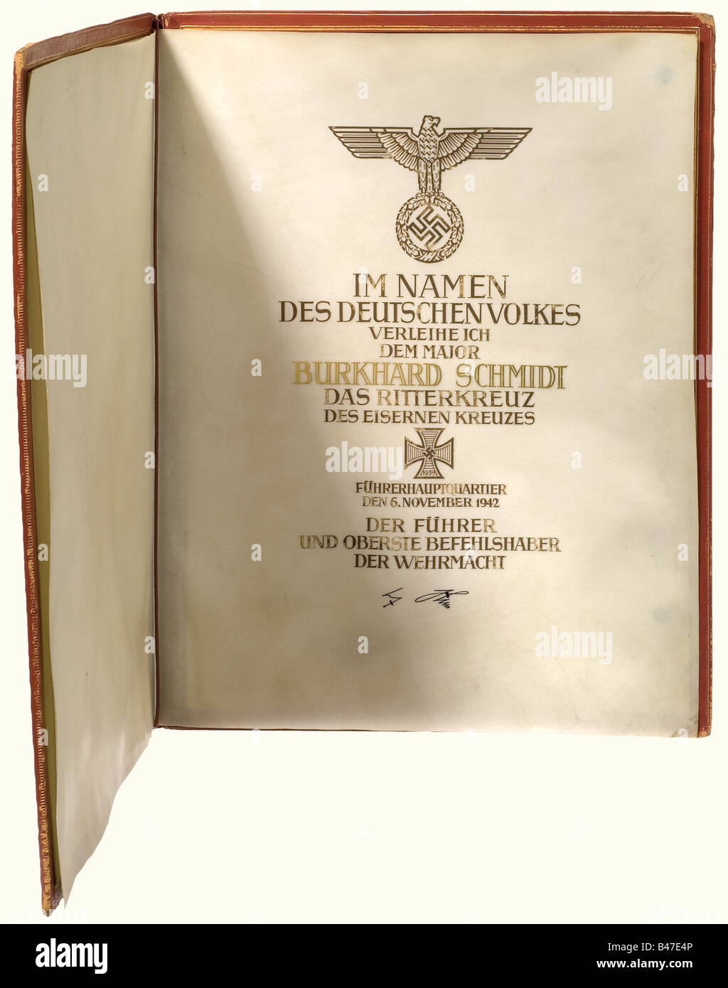 Major Burkhard Schmidt - un Premio Citation e cartella per il Cavaliere´s Croce della Croce di ferro 1939 per il 6 novembre 1942., UN grande formato, doppio foglio, pergamena documento con il testo della citazione in inchiostro nero calligrafia e ha sollevato l'oro su Hitler´s firma in inchiostro. Molto ben conservato, la pergamena è leggermente macchiato e il materiale mostra una certa ondulazione. Nell'originale cartella dei premi in pelle rossa con decorazione in oro stampato, il lato destro dell'interno coperto di pergamena è firmato: 'Frieda Thiersch'. Molto ben conservato con angoli dentati ed ed, Foto Stock