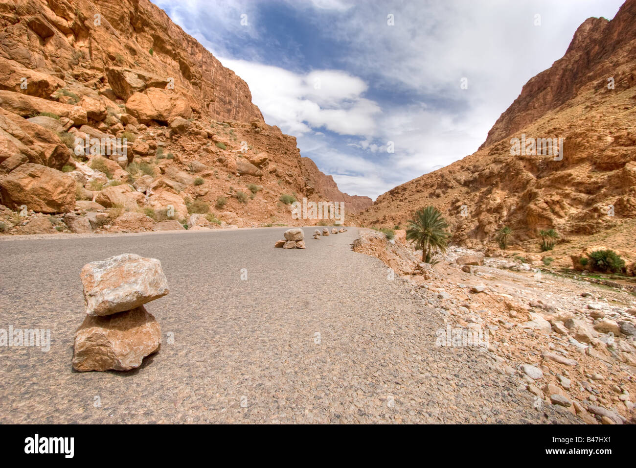 Pietre sul deserto selvaggio road con drammatica sky todra valle del Marocco Foto Stock