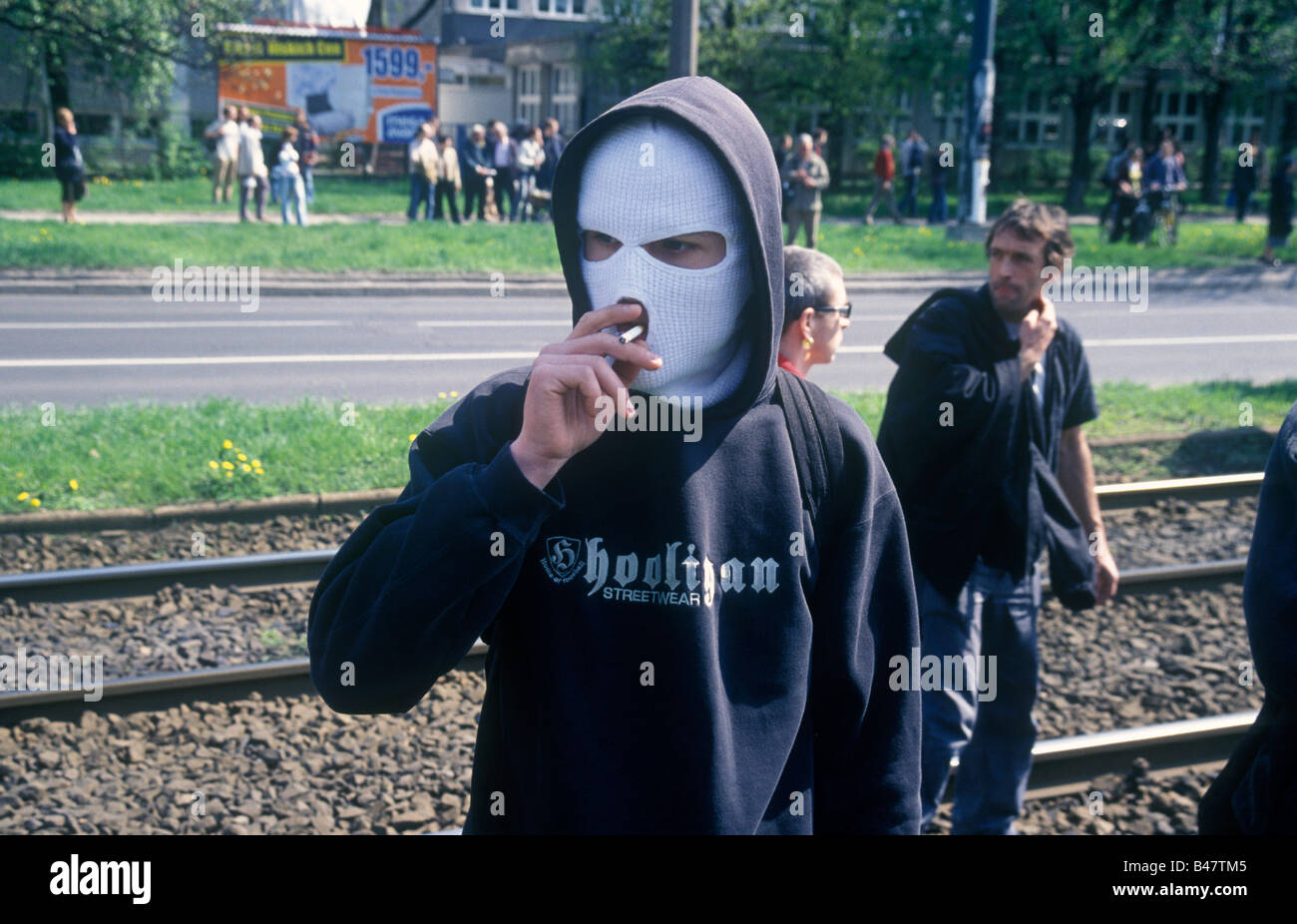 Hooligan indossando passamontagna maschera facciale su una strada di fumo  di sigaretta. Varsavia, Polonia Foto stock - Alamy