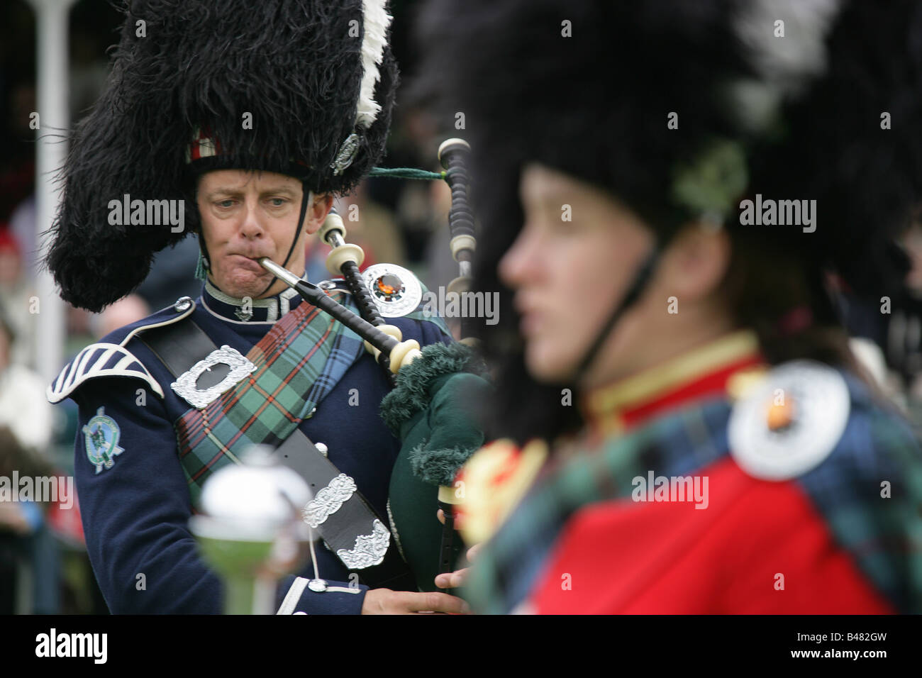 Villaggio di Braemar, Scozia. Piper dal Ballater & District Pipe Band a Braemar raccolta di giochi. Foto Stock