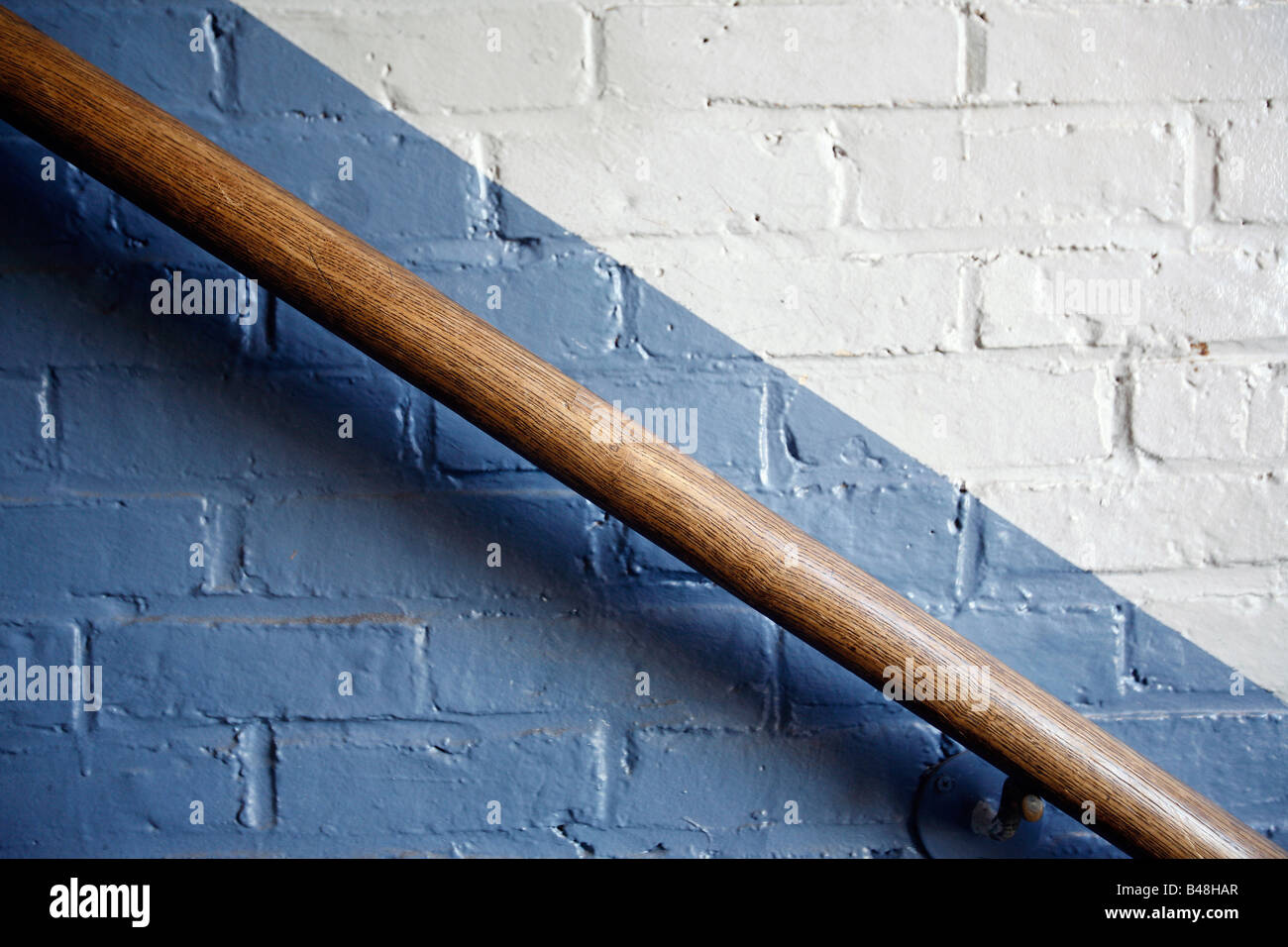 Graphic diagonale ringhiera in legno dipinto di un muro di mattoni Foto Stock