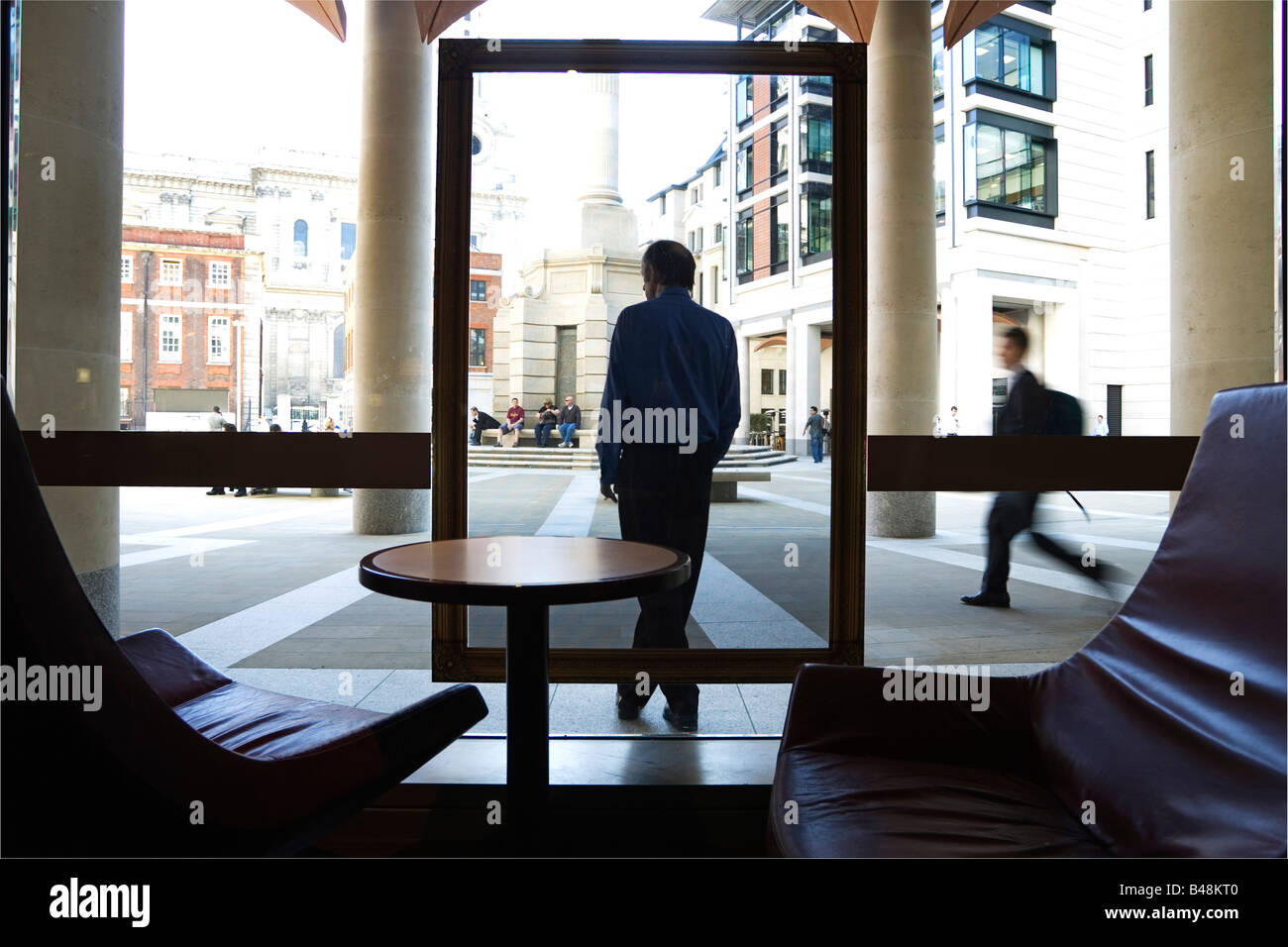 Uomo in piedi al di fuori di un coffee shop di fumare una sigaretta Foto Stock