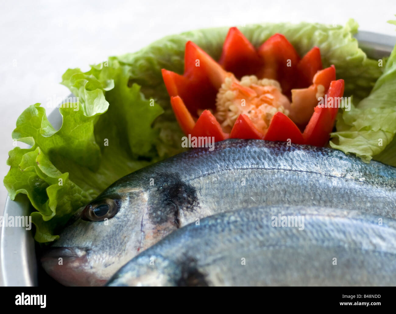 Bass fresco pesce con verdure pronte da cuocere Foto Stock