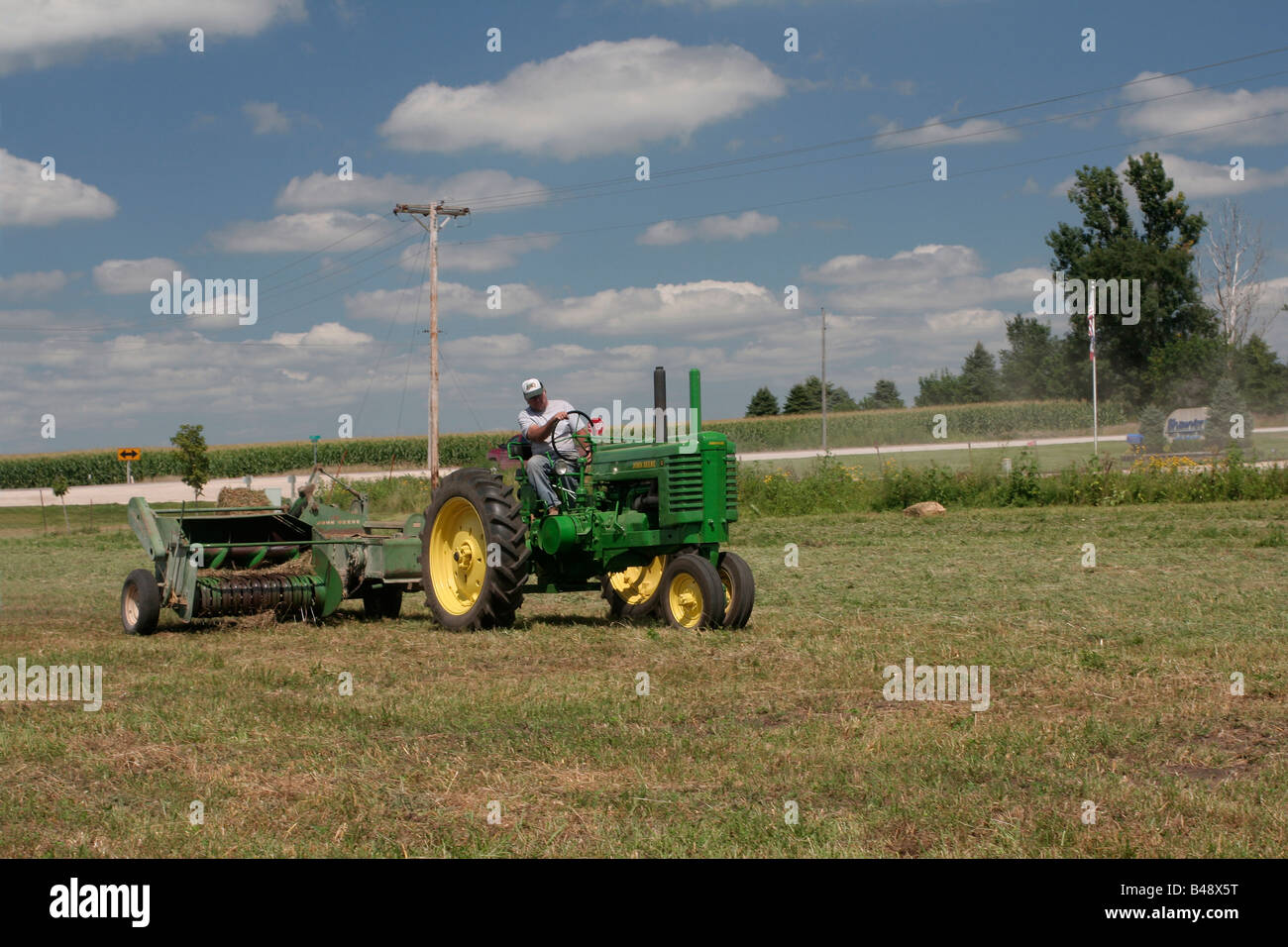 Pressatura di fieno con attrezzature John Deere Foto Stock