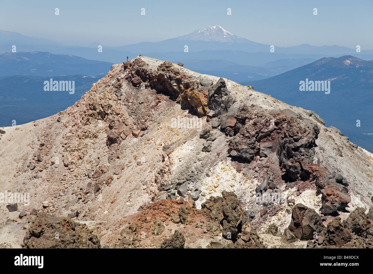 Il bordo del cratere di Lassen Peak vulcano, con Mt. Shasta in background Foto Stock