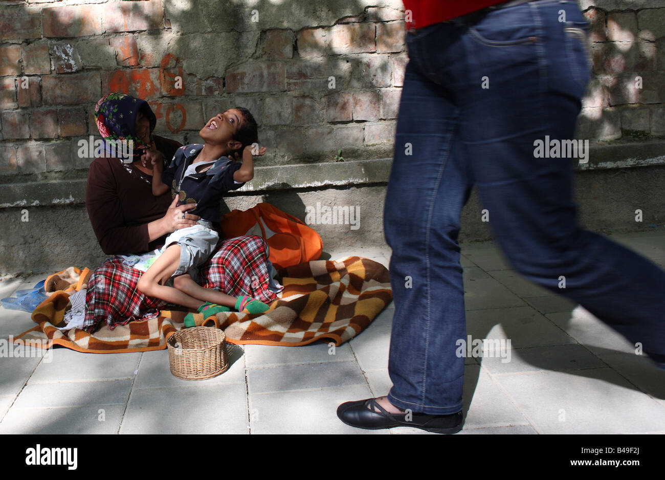 Crippled Roma gypsy boy e vecchia donna a mendicare per strada a Tirana, Albania Foto Stock