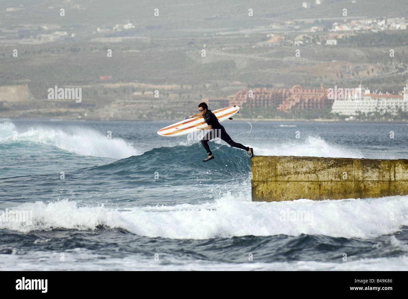 Surfer tuffarsi nell'Oceano Atlantico, Adeje, Spagna Foto Stock