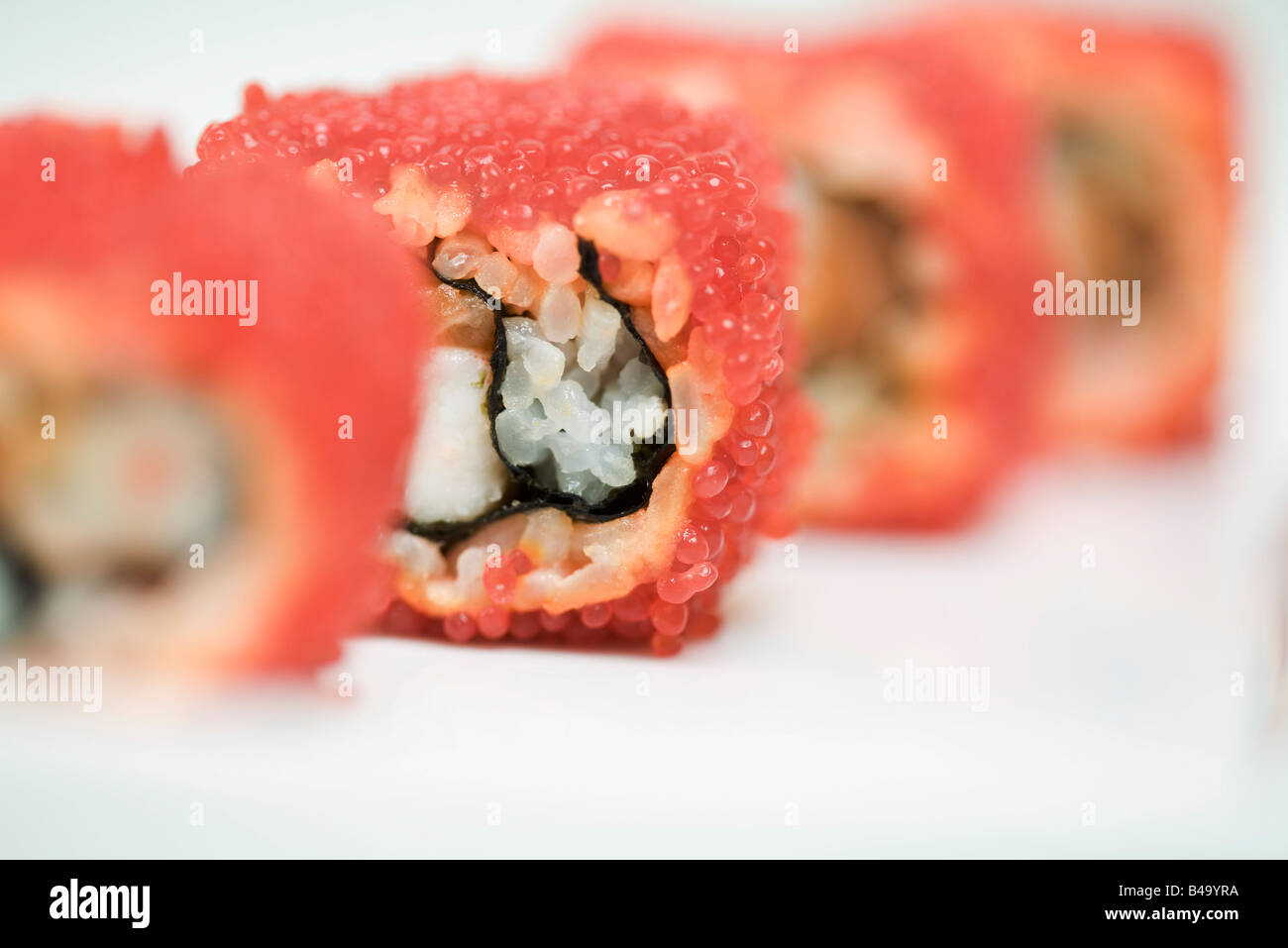 Vista ritagliata di maki sushi arrotolato in rosso flying fish roe, close-up Foto Stock