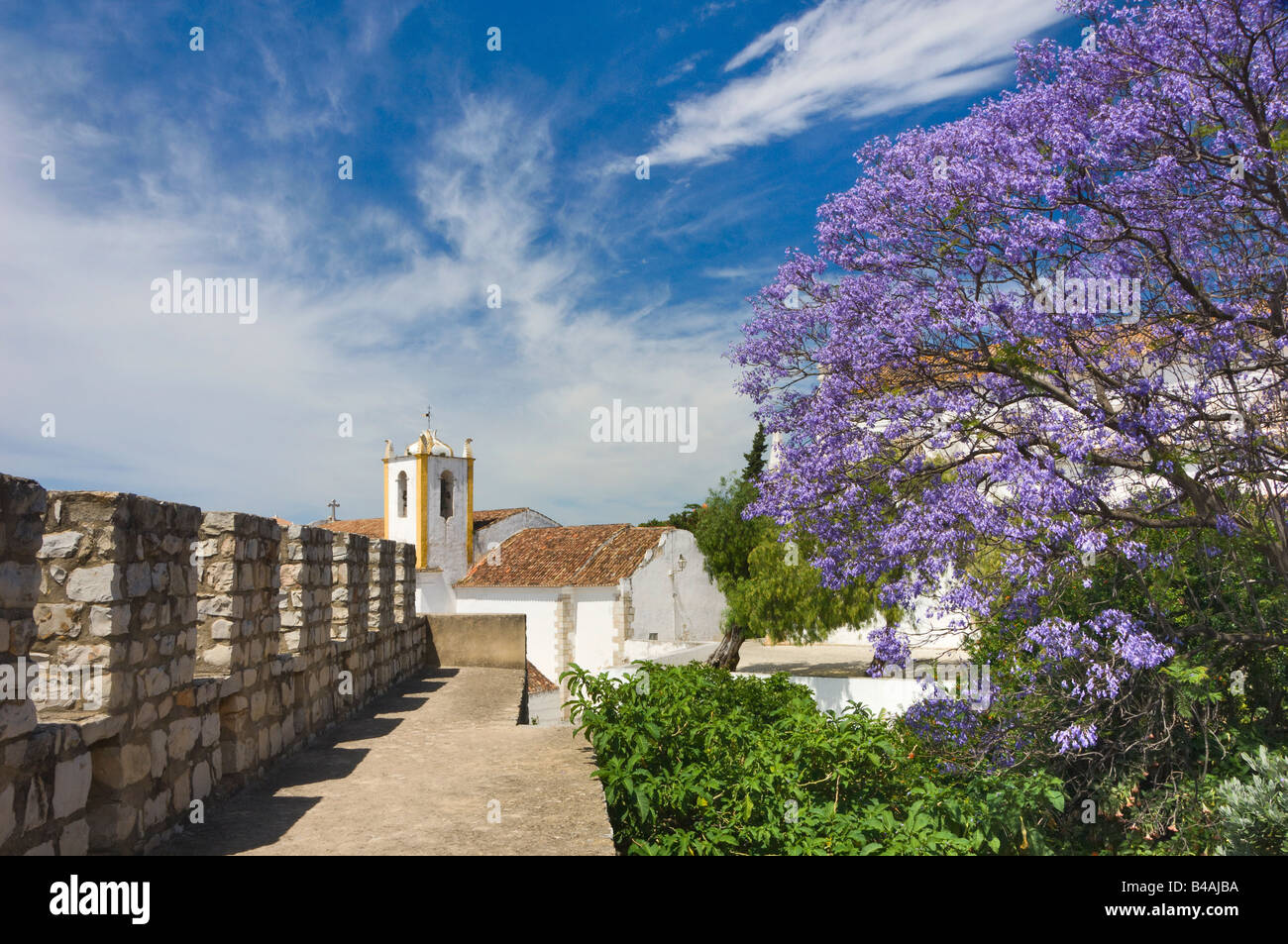 Tavira, mura del castello, Igreja chiesa Matriz e Jacaranda albero in fiore Foto Stock