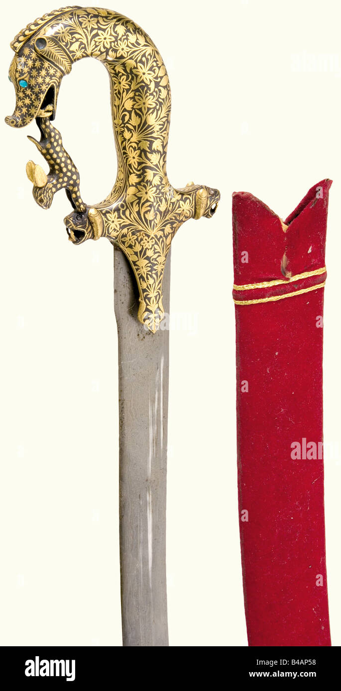 Una tulwar dorato, India, circa 1900 curvata, a bordo singolo, lama di acciaio annacquato con marchi smith stampigliati sul lato opposto. La superficie del hilt di ferro è interamente coperta con decorazione floreale oro-intarsiato e ha un pommel testa mostro. I quillons hanno teste del leone finals. Il fiocco a cavallotto è sagomato come un lepre. Gli occhi sono rispettivamente turchese e rosolia (alcuni mancanti). Scabbard di legno rivestito di feltro. Lunghezza 93 cm. Storico, storico, 1900s, 20th secolo, 19th secolo, spinta, spinte, armi a mano, armi a mano, arma a corpo, mischia Wia, Foto Stock