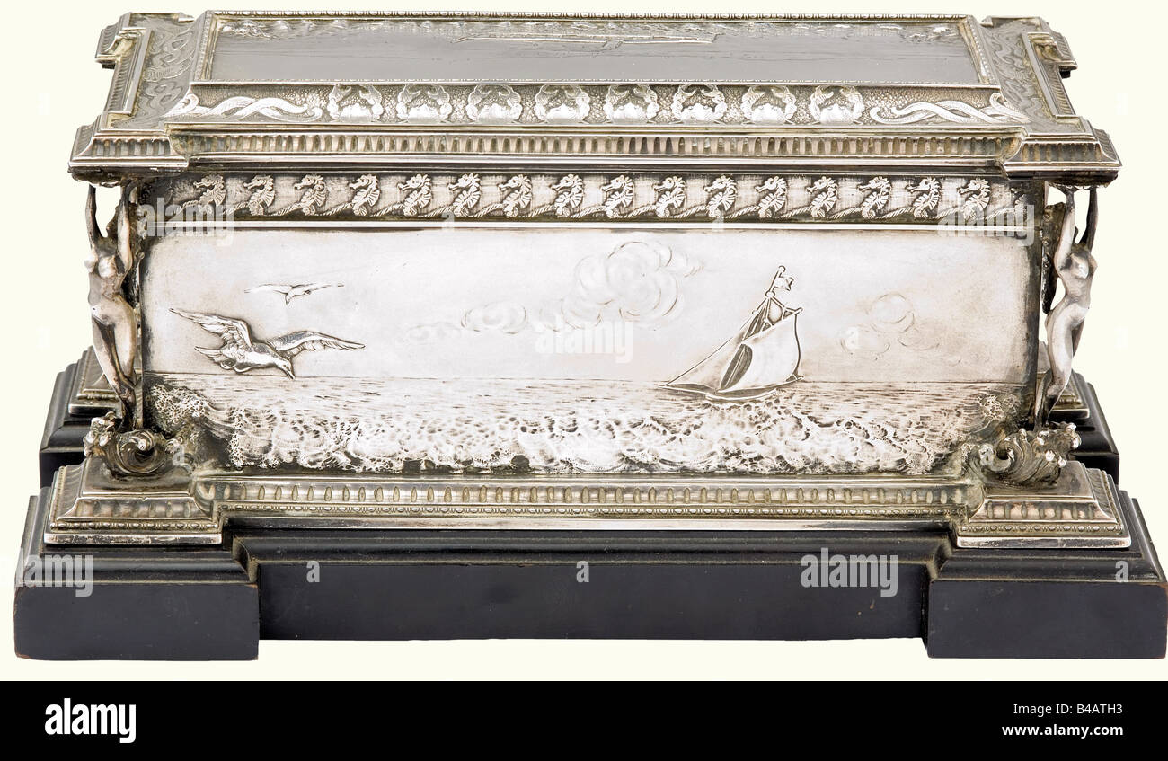 Arciduca Francesco Ferdinando d'Austria-Este - scatola di sigari d'argento, Particolareggiato presente d'onore all'erede apparente in occasione della sua visita alla base navale Brioni. Sul coperchio e sui lati scene marittime, incorniciate da fregi che mostrano animali marini, sui quattro angoli ninfe schiuma-nati. Da un lato una placca di smalto blu con la dedica 'Se k. u. Hh. Ehzg.Franz Ferdinand Brioni - 18. Dez. 1903' e incise firme di faksimile degli ufficiali e degli ospiti d'onore. Su una base di legno ebonizzata. Peso circa 1,3 kg, 25 x 12 x 11 cm. L'applicazione erede, Foto Stock