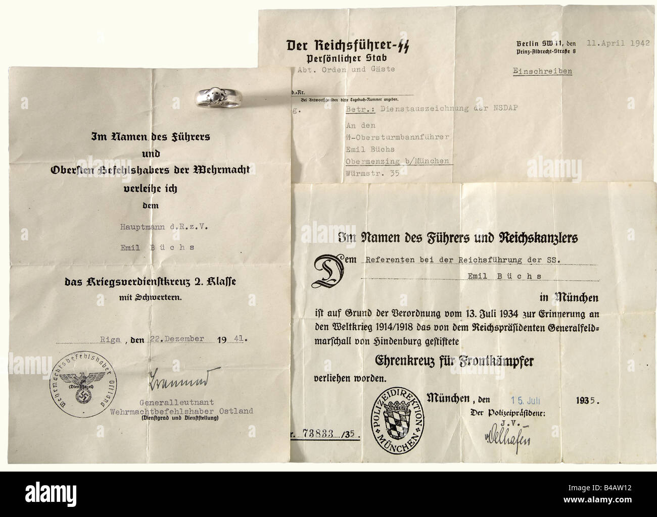 SS-Obersturmbannführer Emil Büchs - anello della testa Della morte SS, e tre documenti. L'anello è indossato liscio, con testa Di Morte sovrapposta identificabile e l'iscrizione dedicatoria incisa 'S.lb. Büchs 30.6.34 H. Himmler'. Sono inclusi i documenti premio per La Croce D'Onore per i combattenti del fronte 1935 per il 'Referenten bei der Reichsführung der SS' ('Consulente per la leadership del Reichs SS') E la classe 2nd di War Merit Cross con Spade 1941 con firma in inchiostro del maggiore generale e del comandante Wehrmacht nell'est Walter Braemer, nonché la lettera di trasmissione, Foto Stock