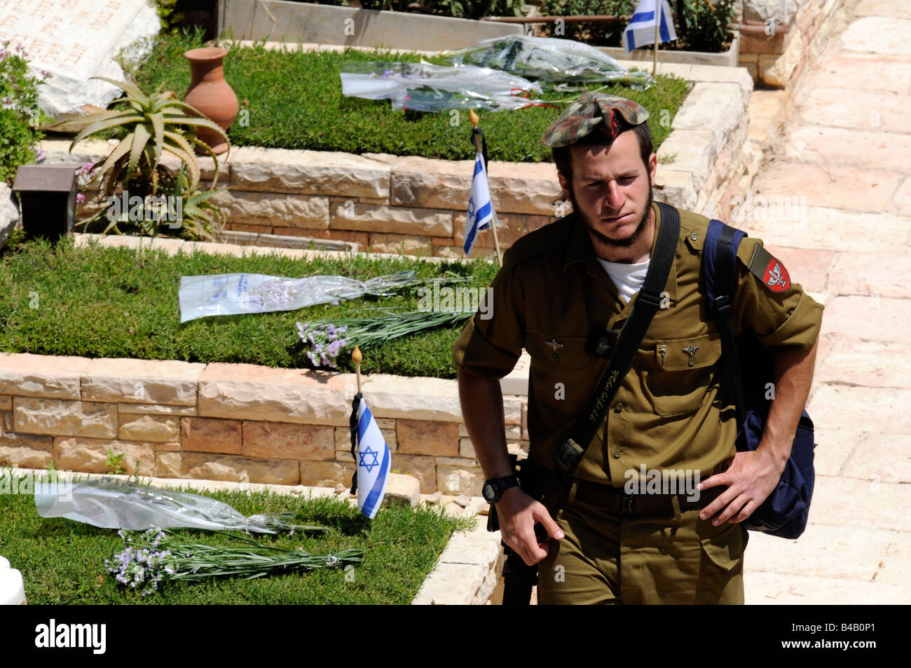 Un soldato israeliano a camminare in un cimitero militare su 'caduti giorno", il giorno appena prima del giorno di indipendenza, in Gerusalemme. Foto Stock