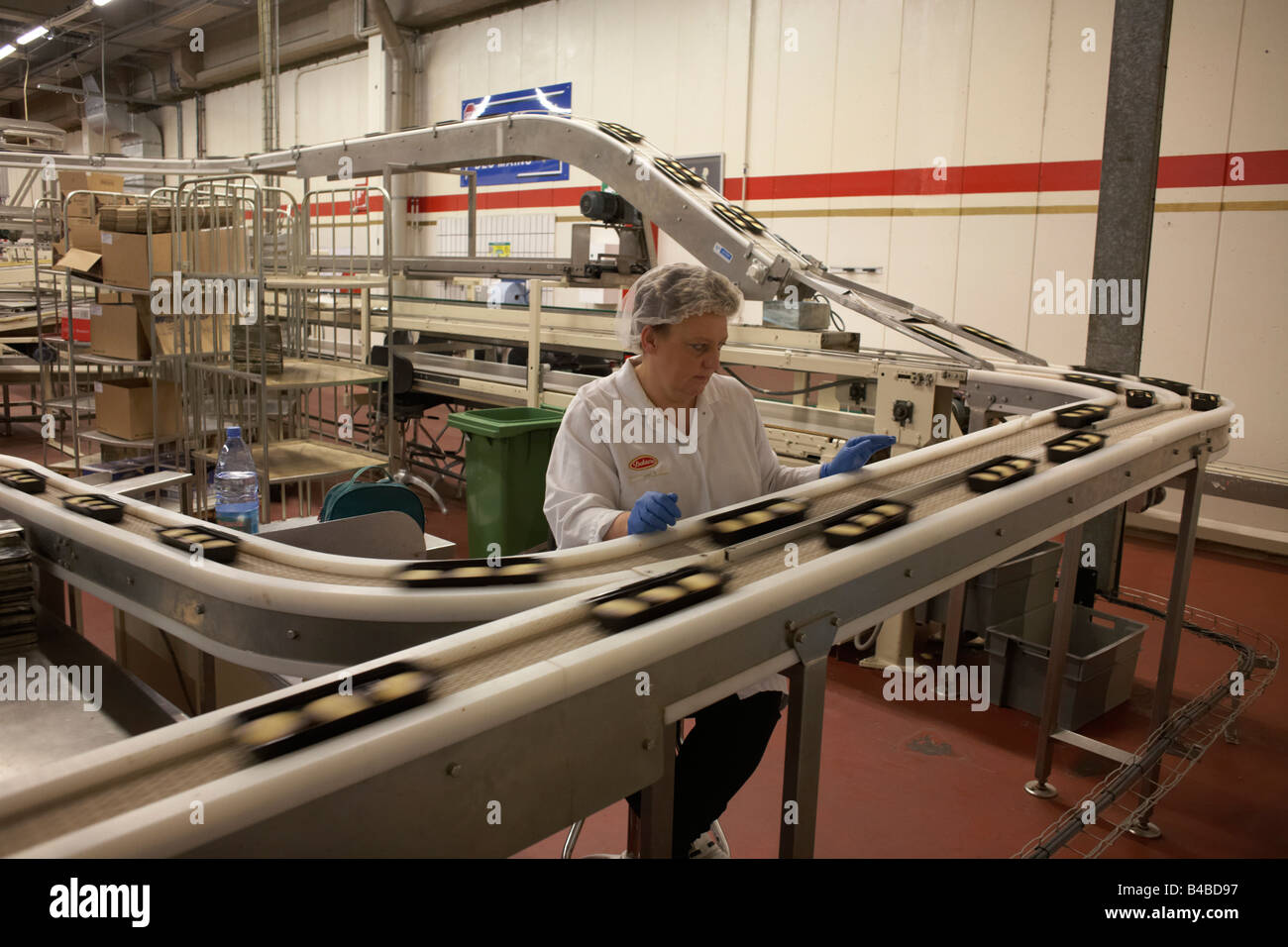 Controllo di qualità di lavoratore ordina tramite una sub-standard momenti biscotti al Delacre biscotto fabbrica di produzione in Lambermont Foto Stock