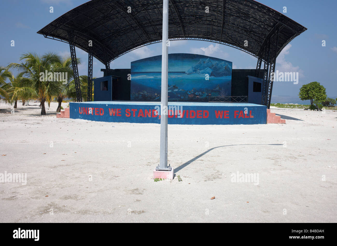 Lo slogan del governo spinge l'unità politica dipinta su un stadio comunale sotto il sole tropicale sulla Meedu isola nella Repubblica delle Maldive Foto Stock