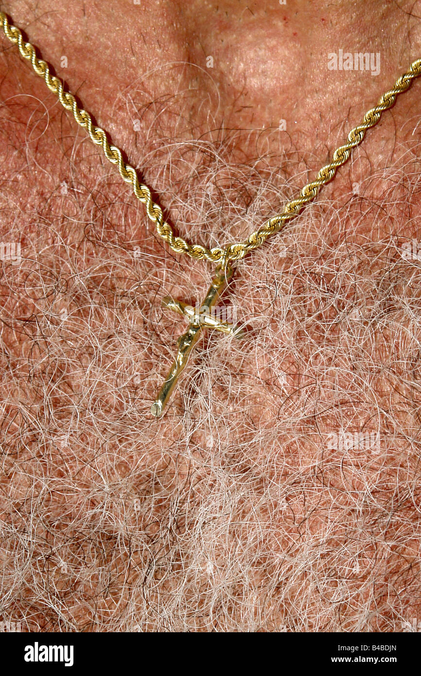 Primo piano di un crocifisso in oro in oro una catena attorno al collo di un molto peloso torace di spazio di copia Foto Stock