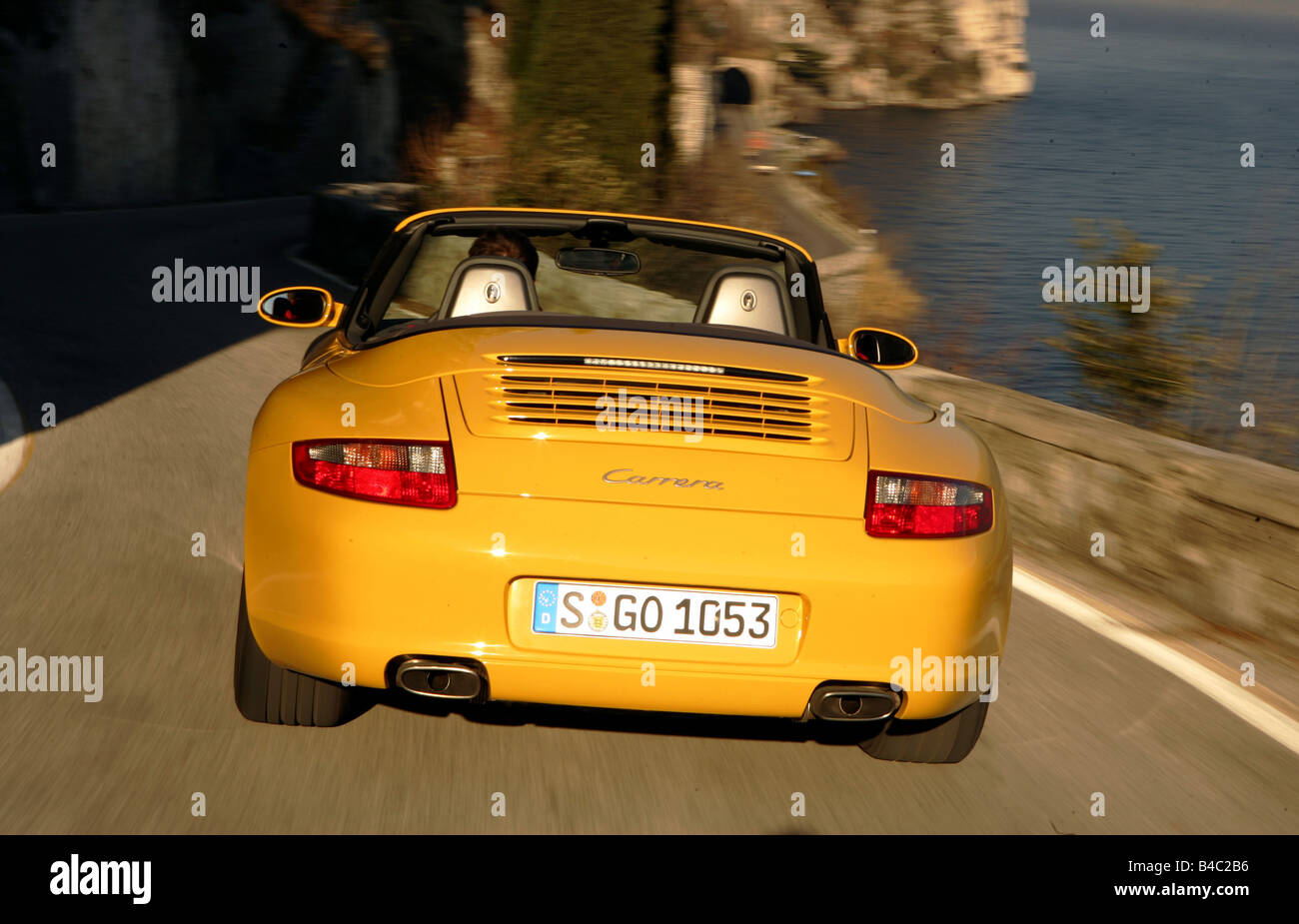 Auto, Porsche 911 Carrera Cabriolet, modello anno 2005-, giallo, guida, vista posteriore, open top, country road, landsapprox.e di monte Foto Stock