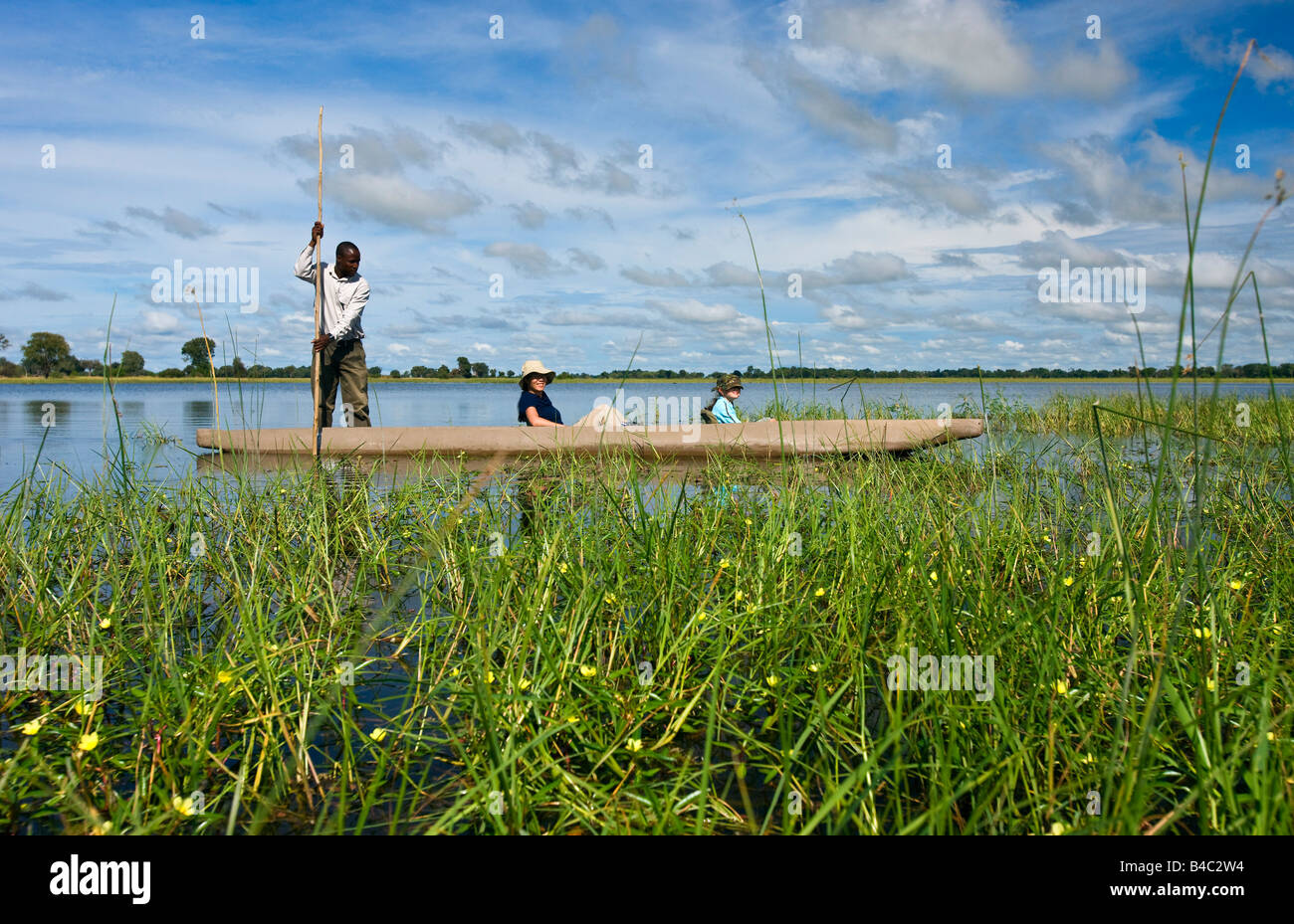 I turisti a cavallo in canoa tradizionale di Okavango Delta, Botswana, Africa Foto Stock