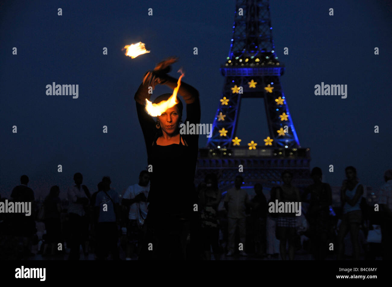 L'artista di strada con la torcia nella parte anteriore dell'illuminato dalla Torre Eiffel a Parigi Francia Foto Stock