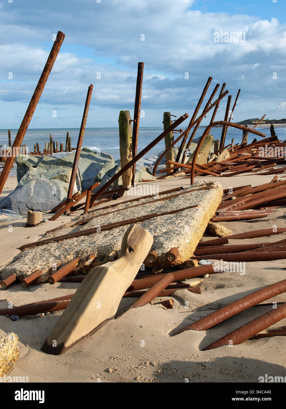 Le difese del mare piegato e contorto dalla azione di onda. Protetto da rocce di happisburgh norfolk Inghilterra Foto Stock