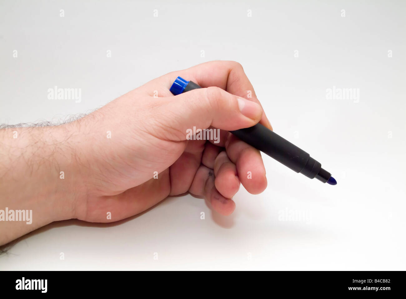 Mano con penna blu su sfondo bianco Foto Stock