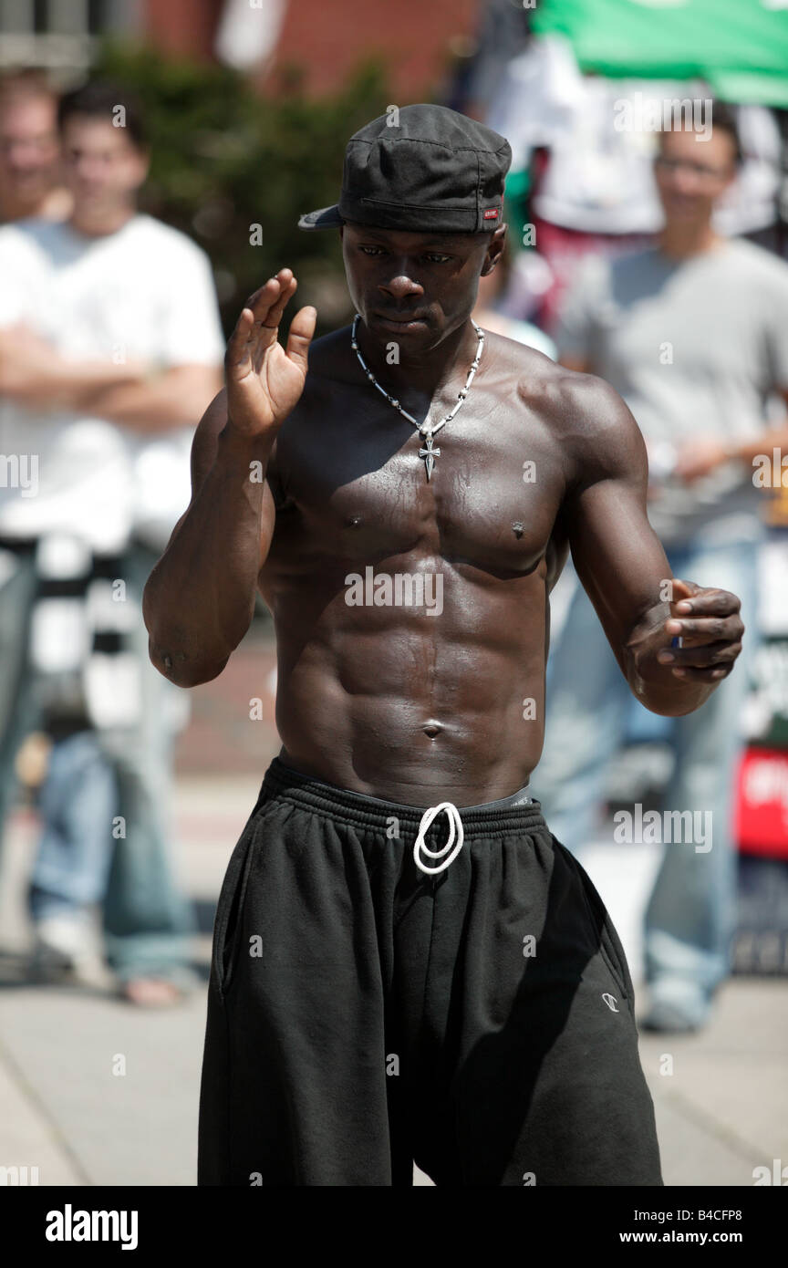 Americano africano Breakdancer maschio in fase di riscaldamento il suo pubblico vicino al parco Steeet Station nel centro cittadino di Boston. Foto Stock