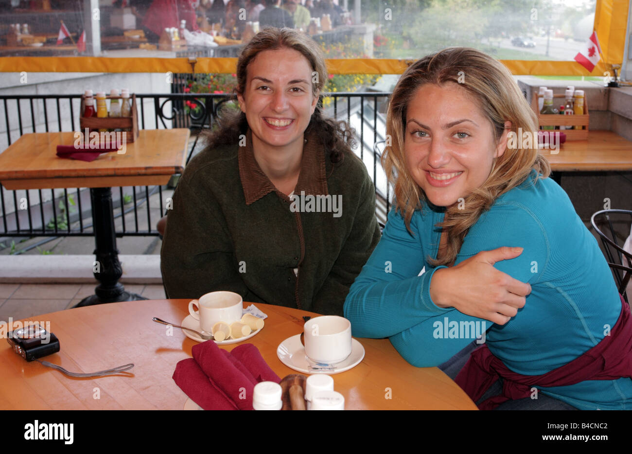 Happy amici di sesso femminile sul patio esterno di un ristorante in Niagara Falls città del Canada Foto Stock