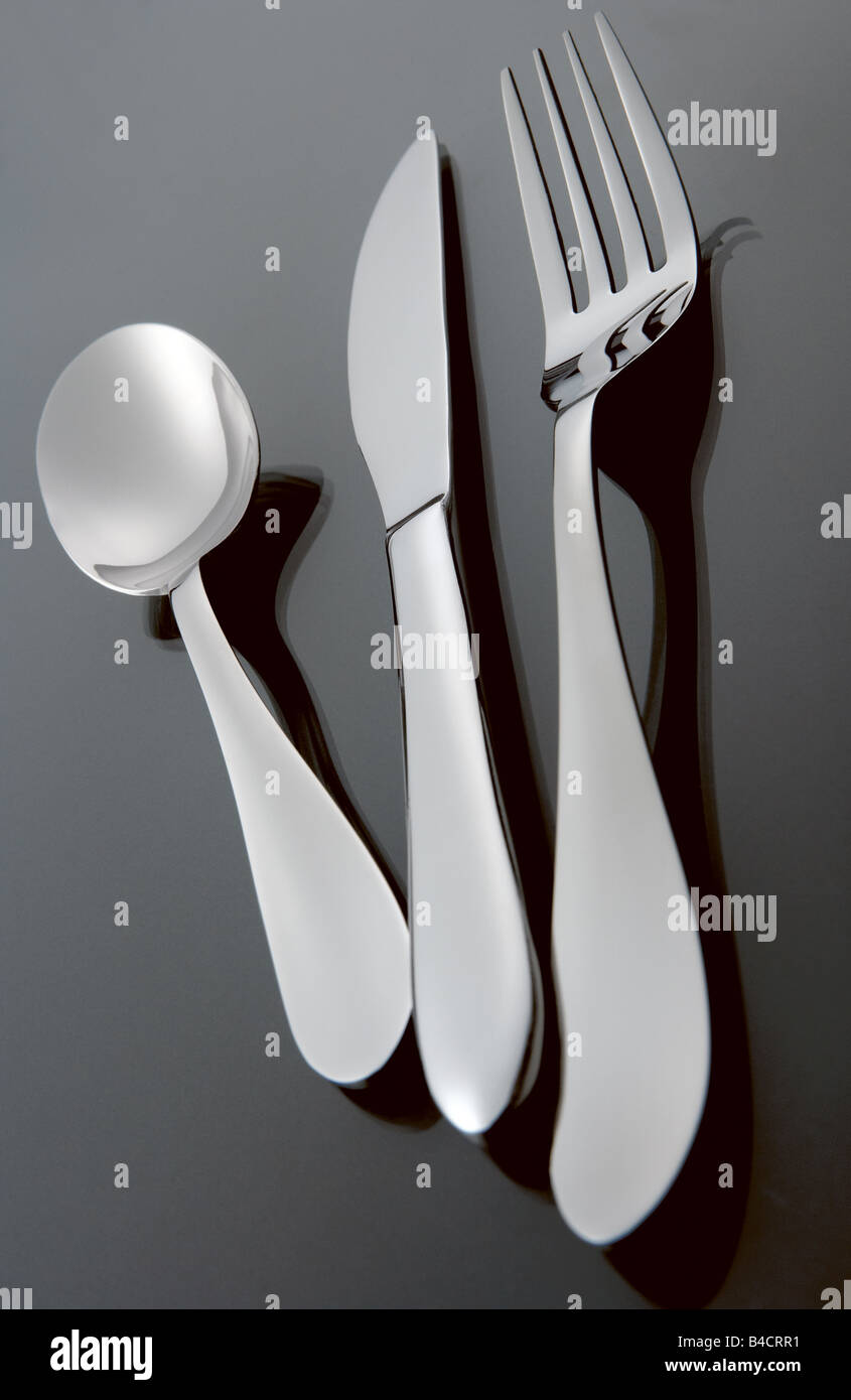 Acciaio inox silver set di posate su un laureato sfondo nero con la riflessione compresi coltello Cucchiaio e forchetta Foto Stock